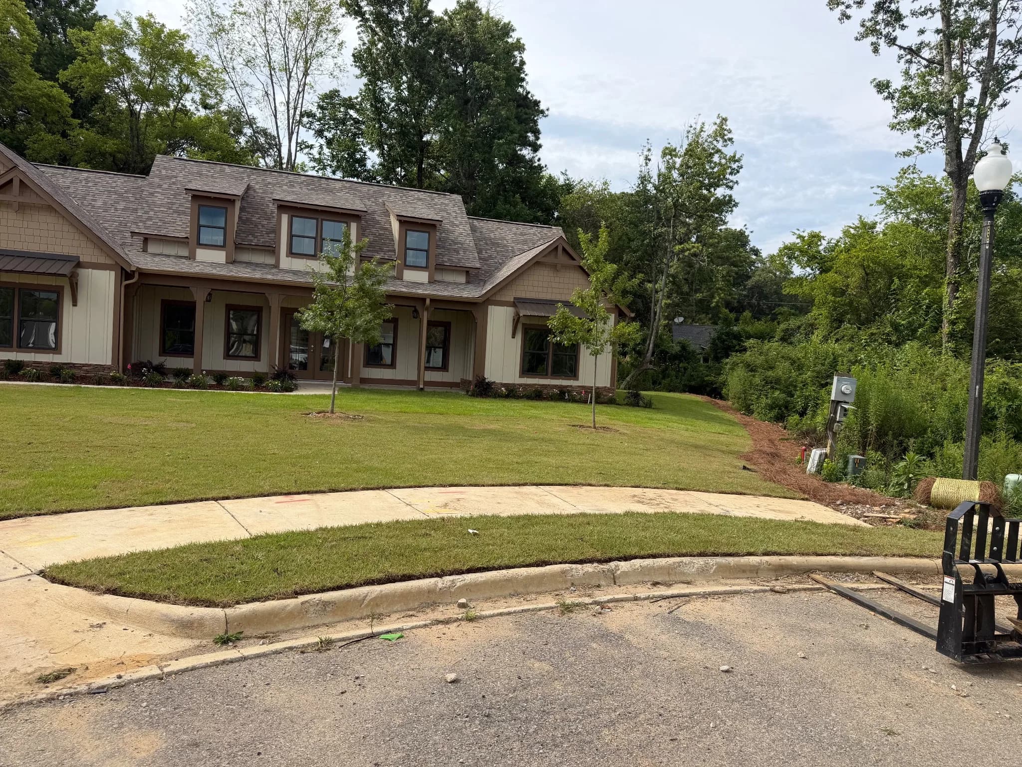 Residential landscape with a house and newly landscaped lawn.